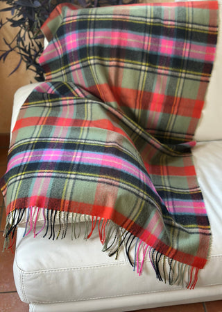 Die Stola liegt ausgebreitet, um den Tartan und seine leuchtenden Farben zu sehen, vor allem, orange, pink, schwarz, grün.
