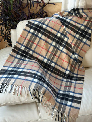 Die Stola ist ausgebreitet aufgelegt. Man kann gut den Tartan Camel Thompson erkennen. Das Schottenkaro basiert auf einem beigefarbenen Hauptton, der mit schwarz, weiß und feinen roten und blauen Streifen gestaltet ist.