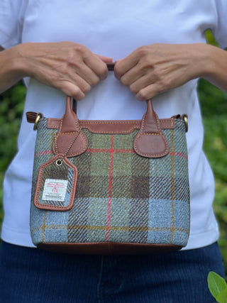 Zu sehen ist die Mini Tote, die am Griff von einer Person getragen wird. Das Foto zeigt das Größenverhältnis der Mini Tote zu einer Person.