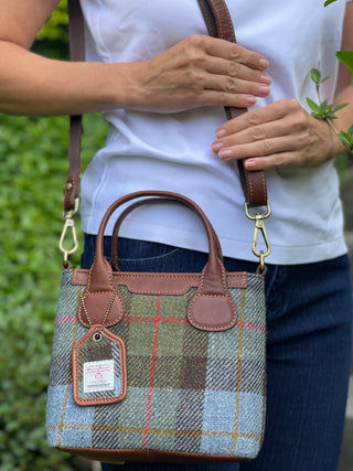 Die Mini Tote ist mit Schultergurt an einer Person abgebildet. Das Verhältnis zeigt die Größe der Tote. Zu ergekennen ist der Schultergurt, der sich in seiner Länge verstellen lässt und schnell abgemacht werden kann.