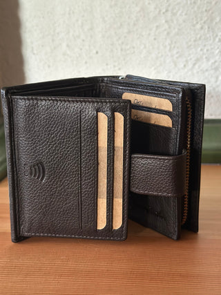 Das Portemonnaie ist aufgeklappt. Zu erkennen sind die Kartenfächer aus dunkelbraunem Leder, insbesondere der RFID-Fach, das einen Schutz für Ihre sensiblen Daten bringen soll. Hinten erkennt man das große Fach für die Geldscheine.