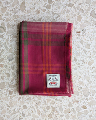 Zu sehen ist ein feiner karierter Merino Schal in den Farben rosa, grün und orange.