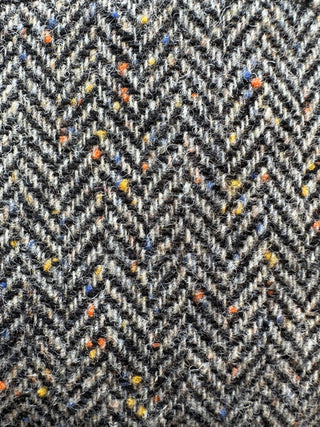 Das Foto zeigt eine Makro Aufnahme des Donegal Tweeds mit seinen Fleckerl.