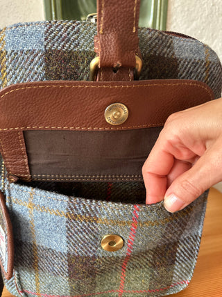 Auf der Vorderseite ist eine kleine Tasche angenäht, die mit Magnetverschluss zu öffnen ist.