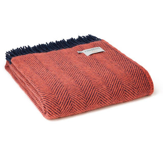 Zu sehen ist eine zusammengelegte klassische Herringbone-Decke aus reiner Schurwolle in den Farben Flamingo und Marineblau